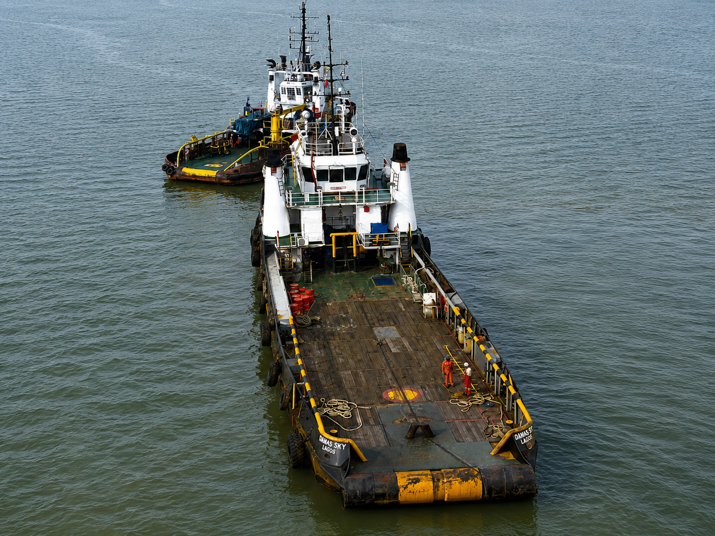 Aerial view of a support vessel towing a barge